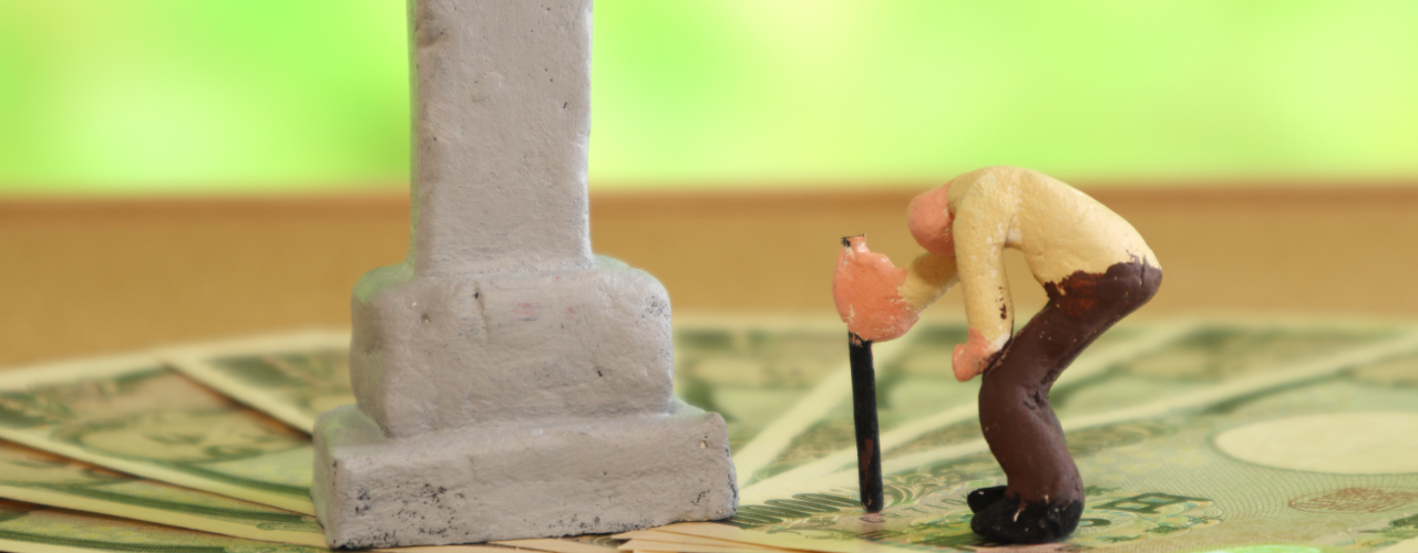 お墓の前でうつむいている老人の写真